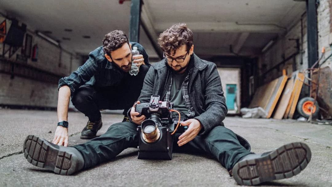Tom Hunter checking a cinema camera with a colleague in a workshop