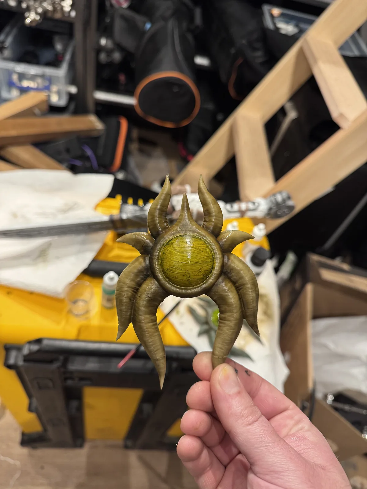 Hand holding the finished gold and green fantasy pendant
