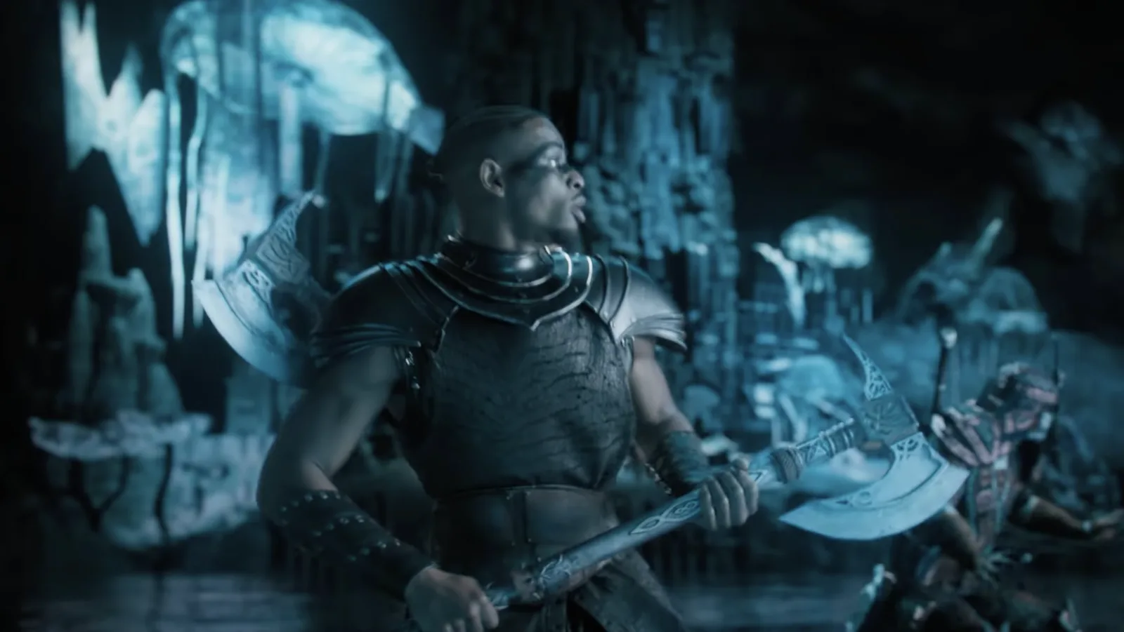 Actor wielding an ornate silver battle axe on a blue-lit fantasy set