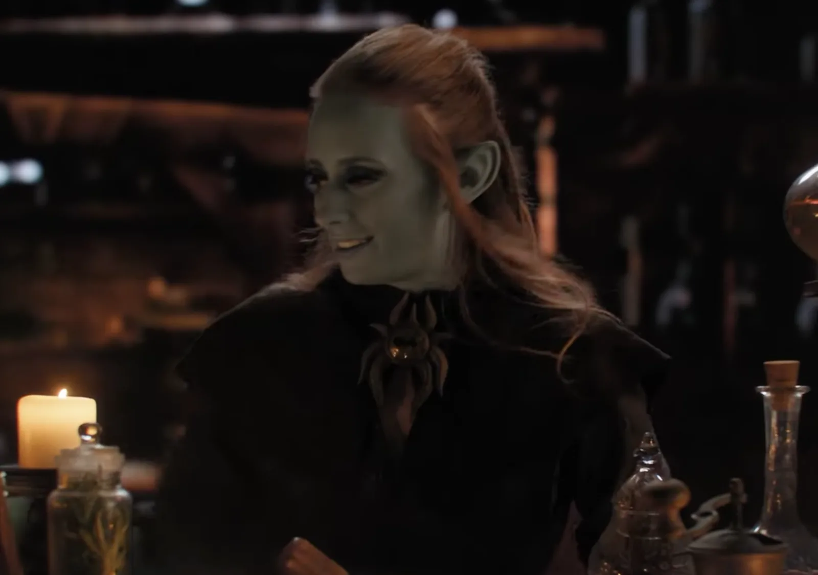 Actor in pointed ears and a dark costume on the candlelit set