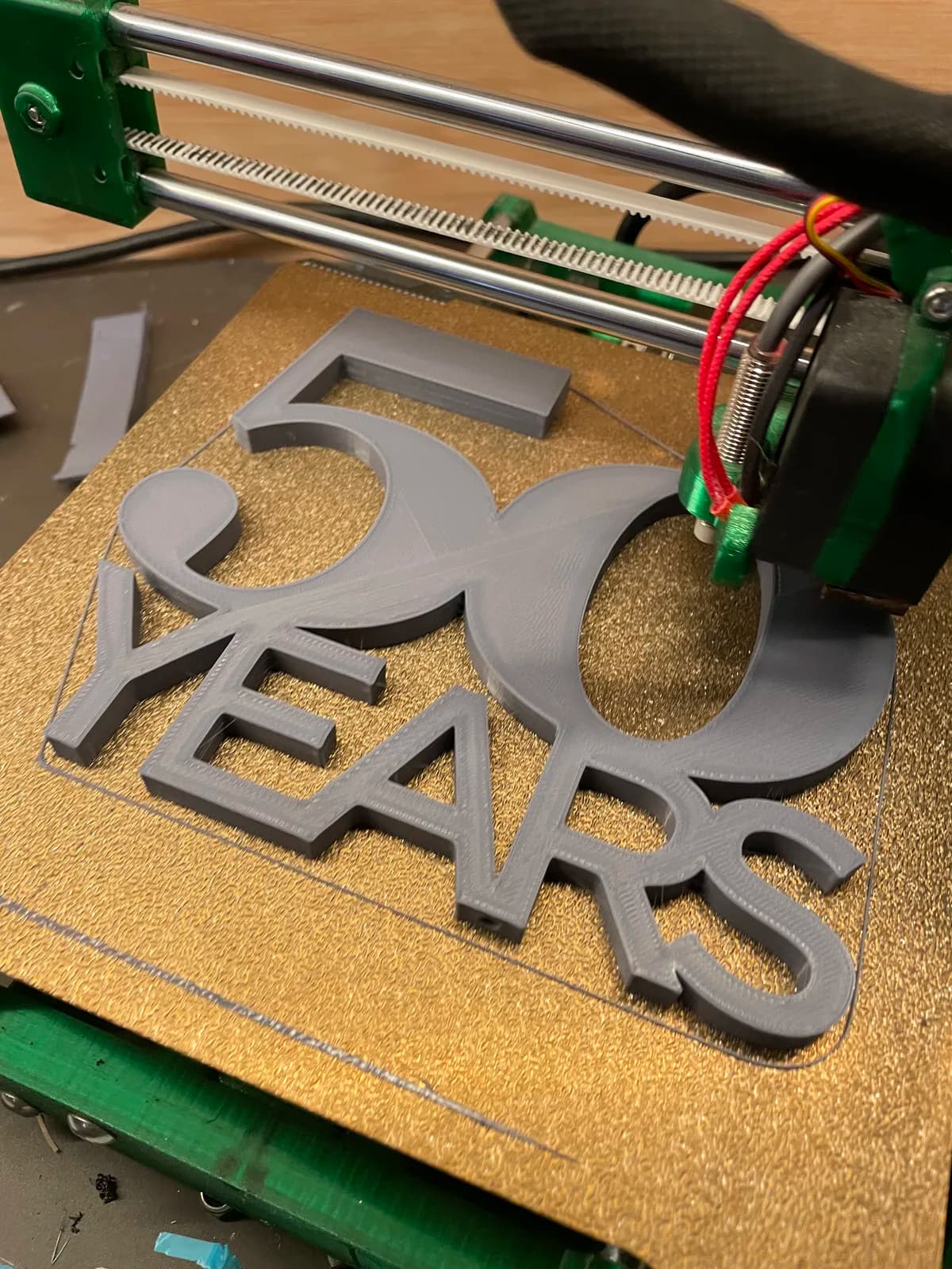A 3D printer making a raised 50 Years anniversary sign