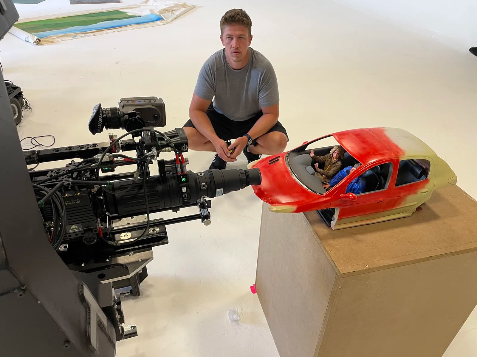 Cinema camera positioned close to the miniature red car for filming