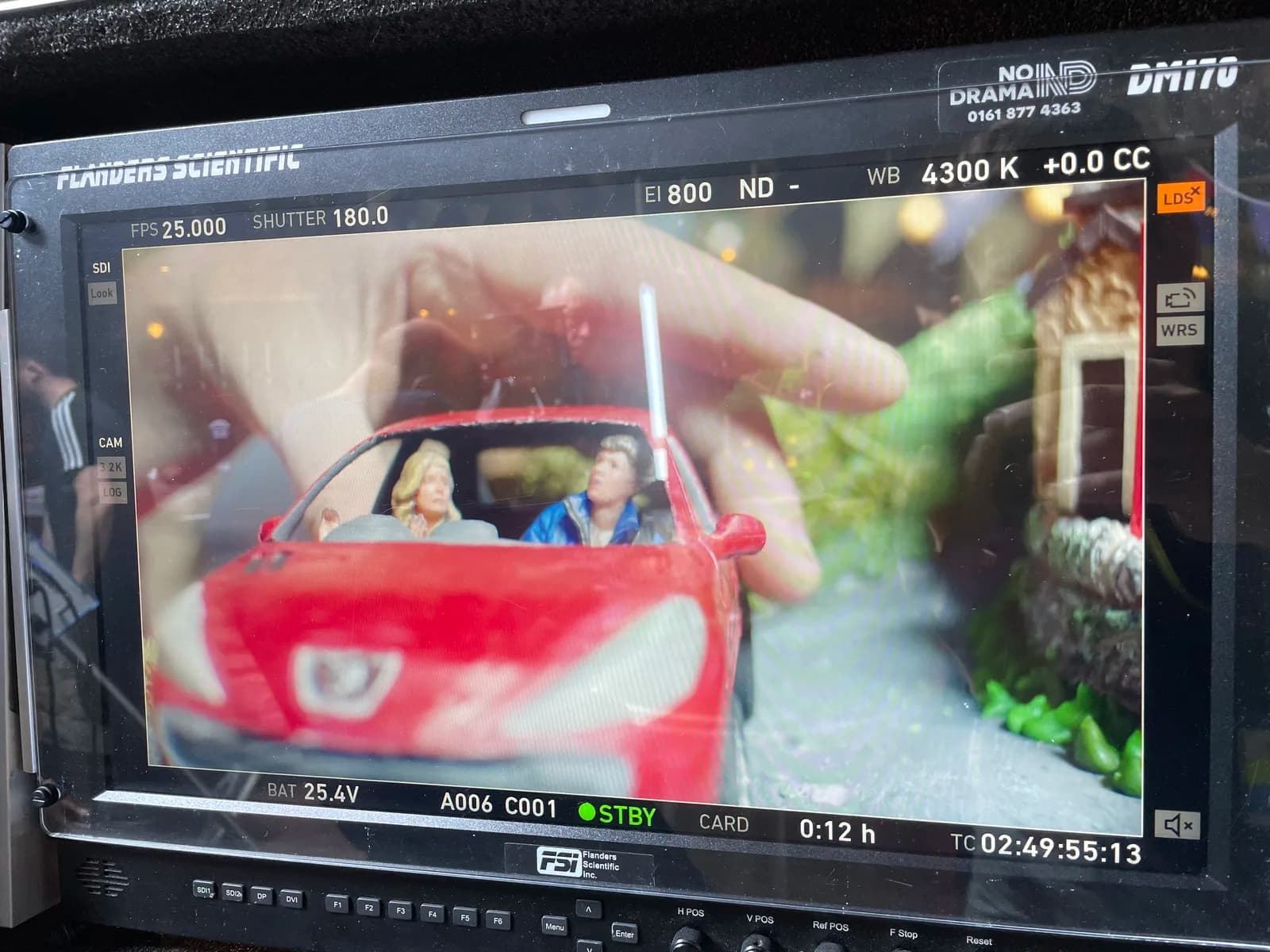 Camera monitor showing the red model car from the front during filming