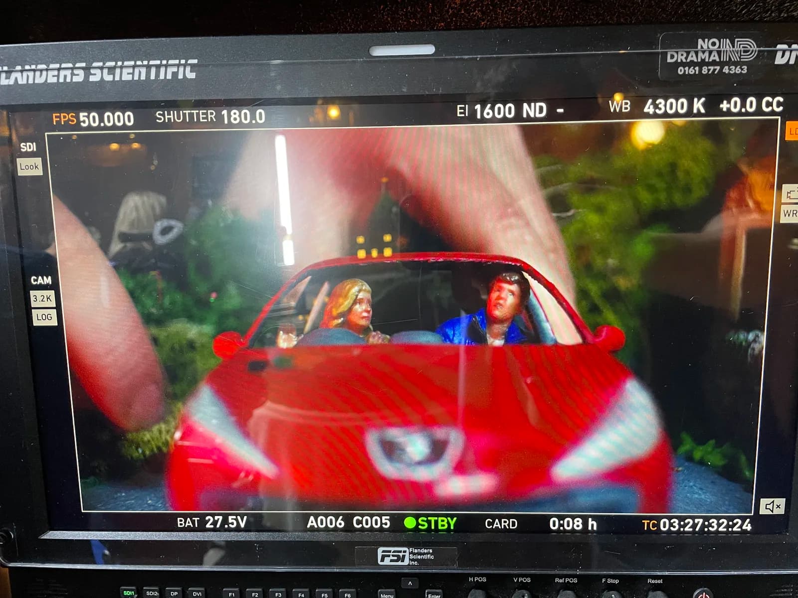 Camera monitor showing a closer front view of the miniature car and figures