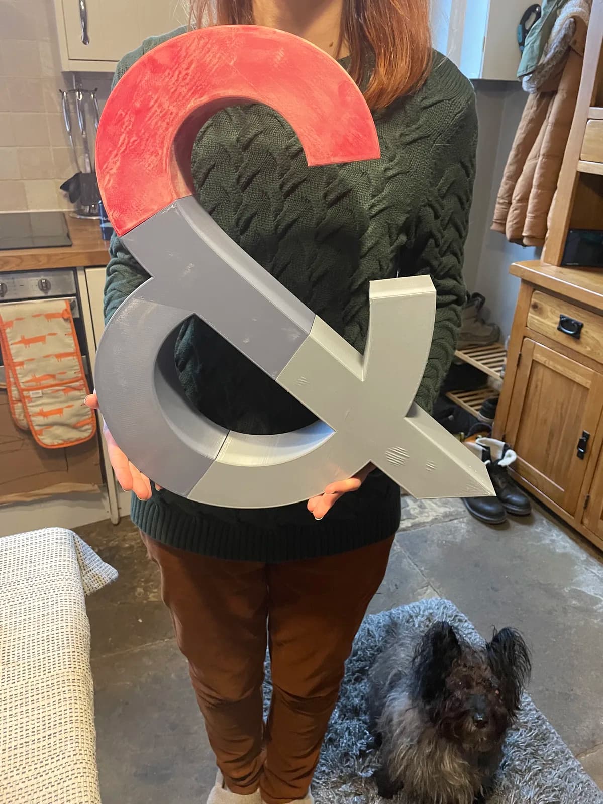 Person holding an assembled ampersand prop with unfinished coloured sections