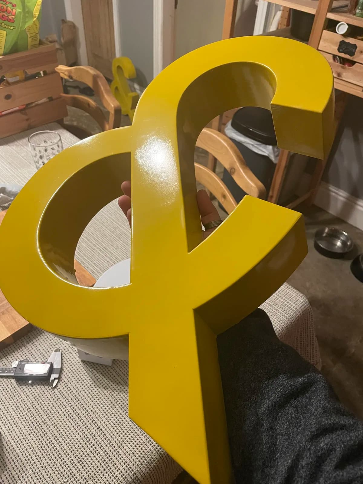 Large yellow ampersand standing on a workshop table