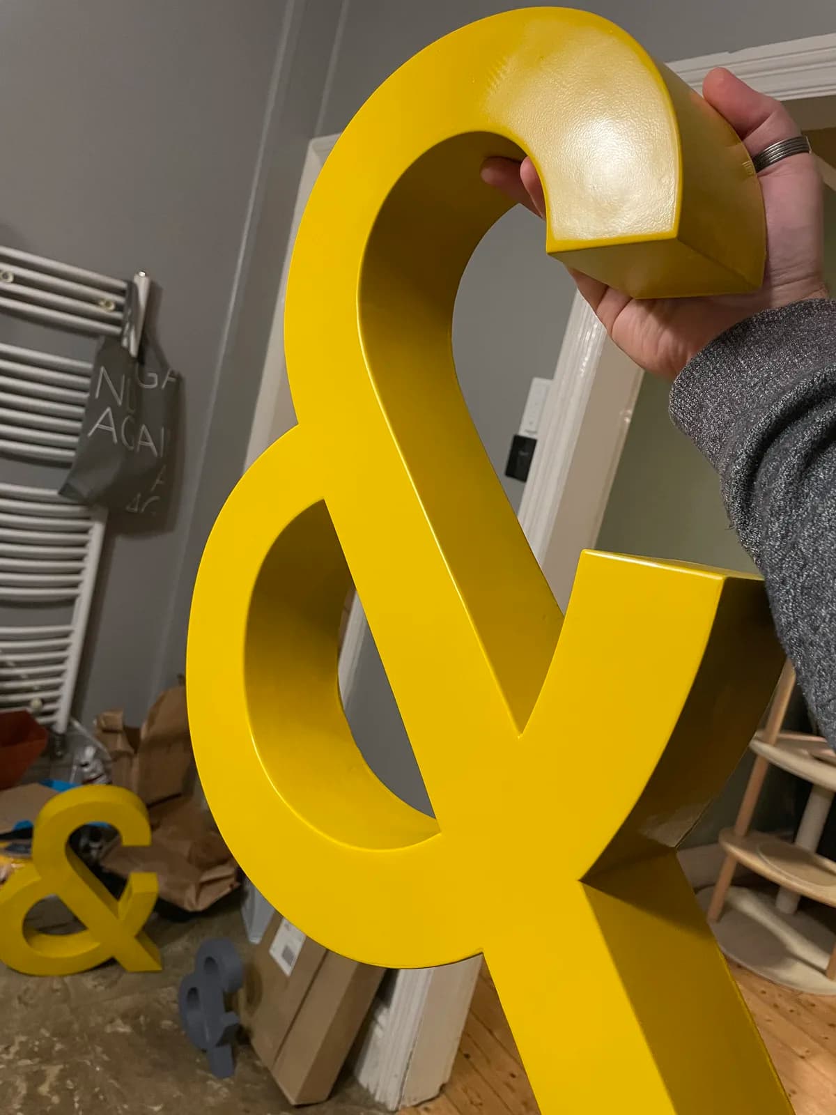 Close view of the yellow ampersand surface held under workshop lighting