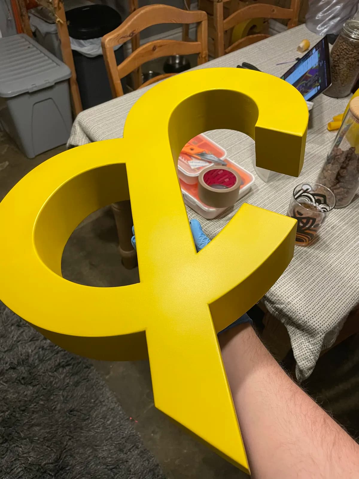 Yellow ampersand held above tools and finishing materials