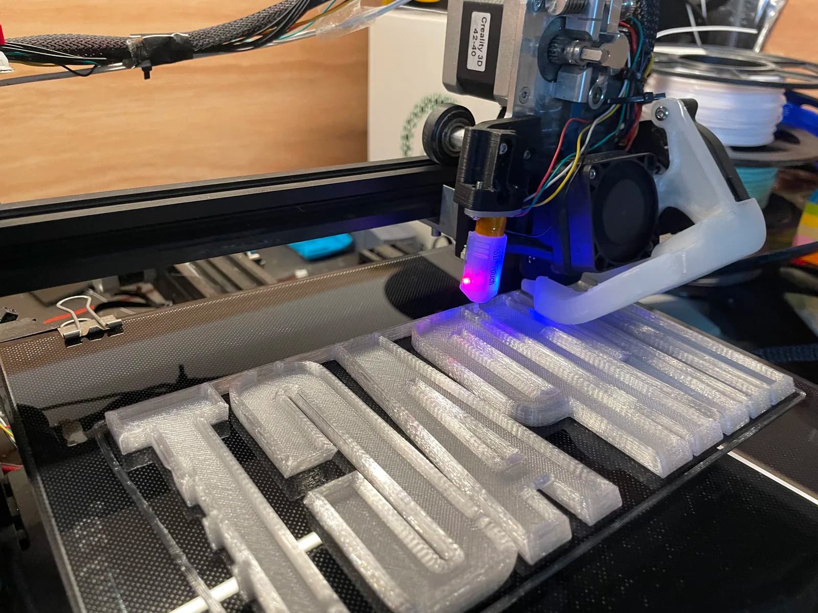 3D printer producing raised letter forms in grey material