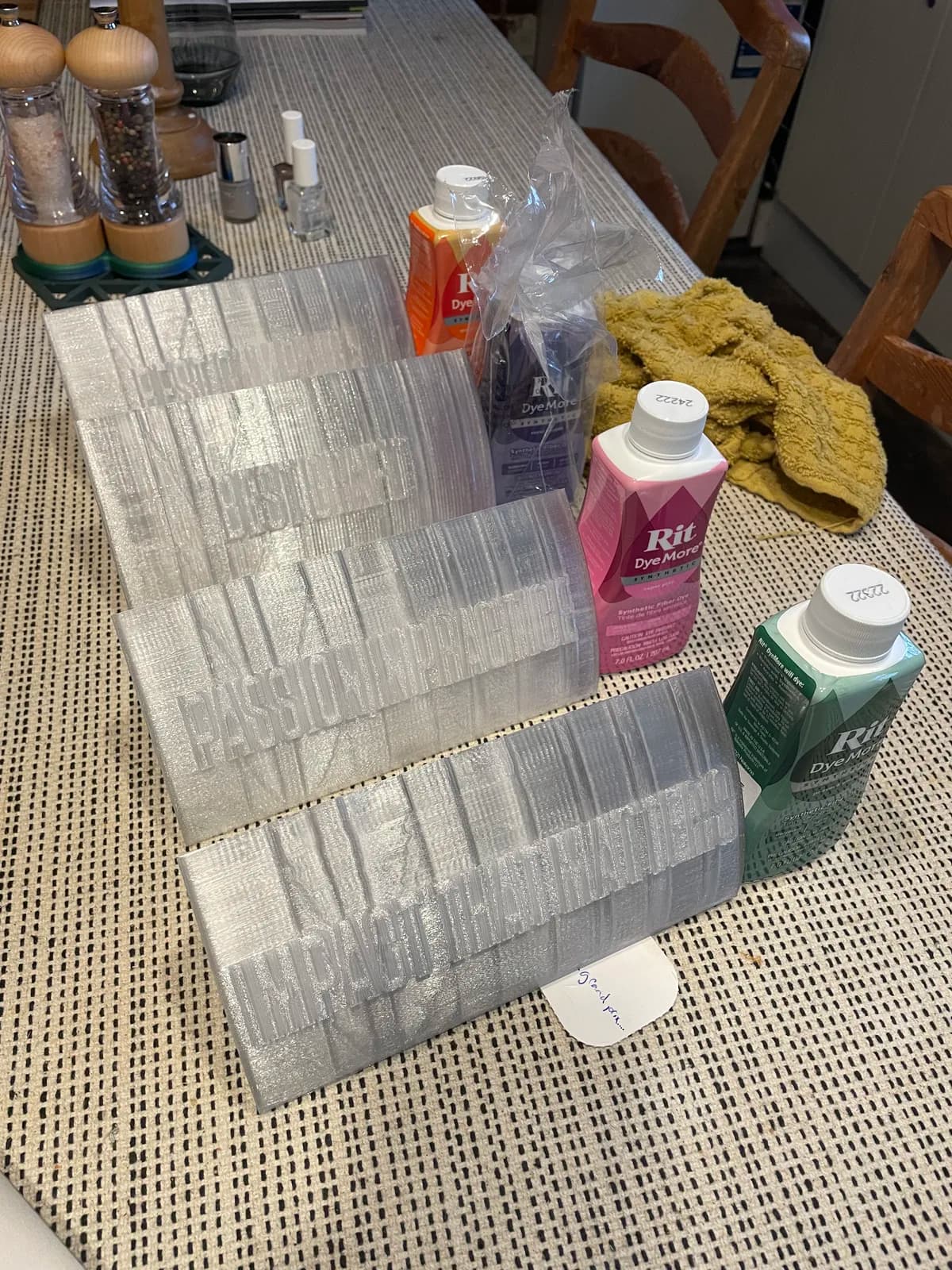 Grey printed components beside cans of coloured finish on a workbench