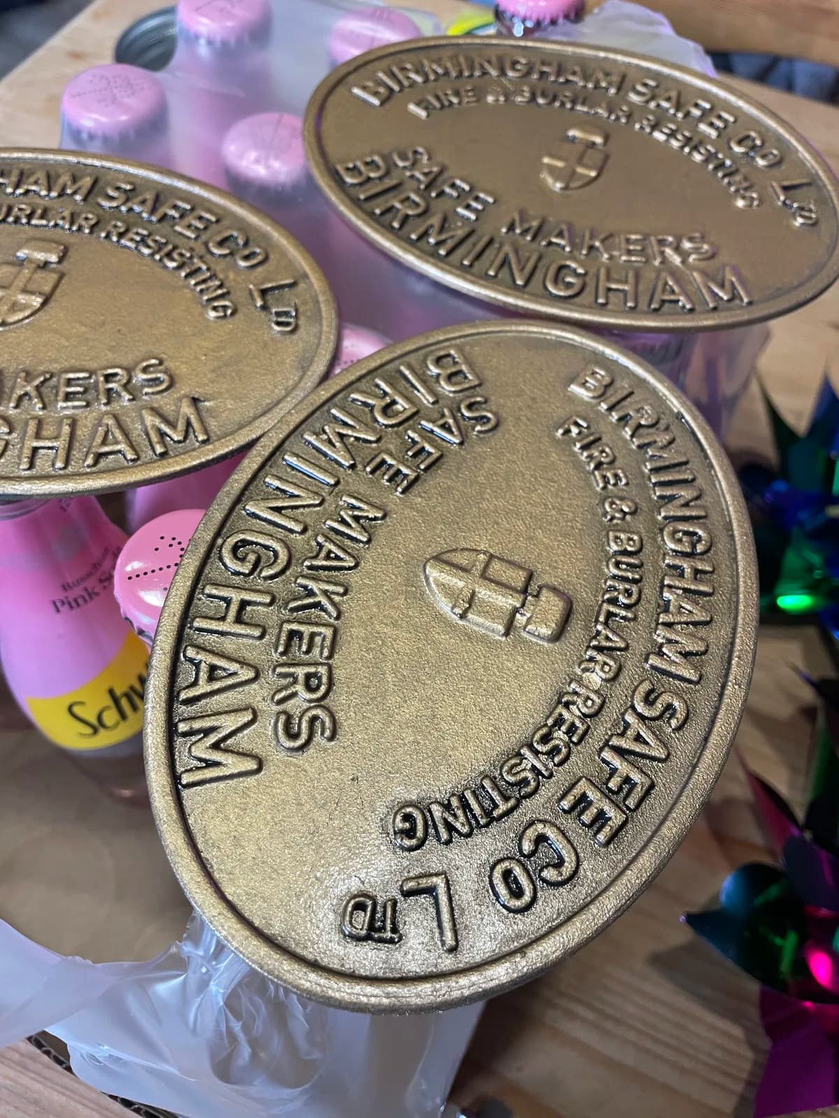 Three circular safe-maker plaques with an aged brass-effect finish