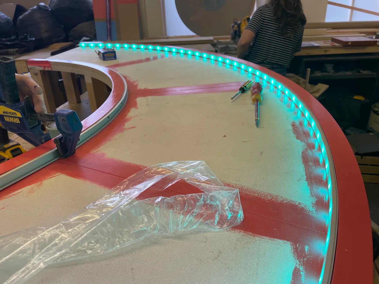 Turquoise light strip following the curved edge of a set piece on a workbench