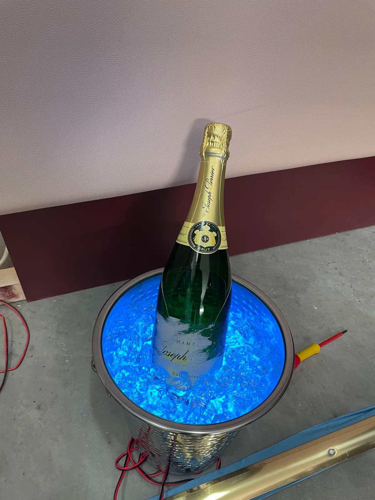 Champagne bottle standing in a bucket illuminated blue from below