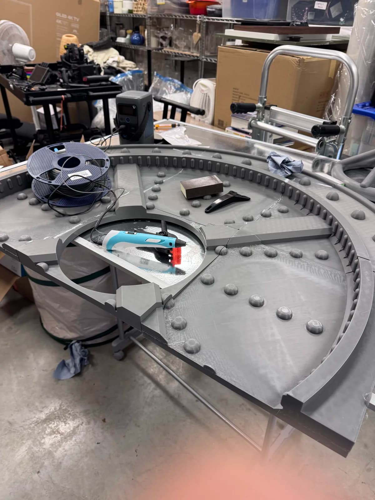 Curved vault-door panel and tools spread across a workshop bench