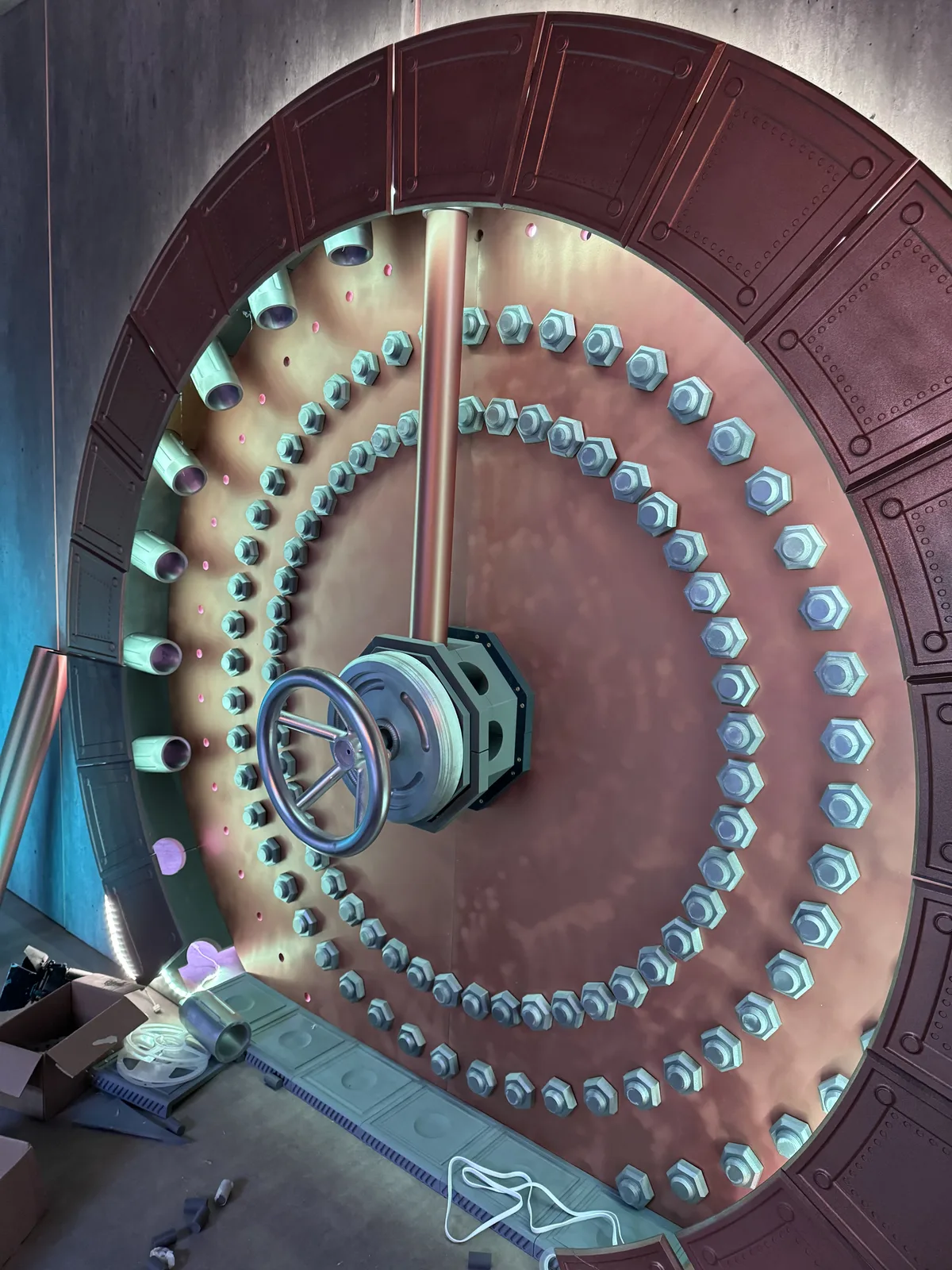 Copper-coloured vault door being fitted with rows of small lights