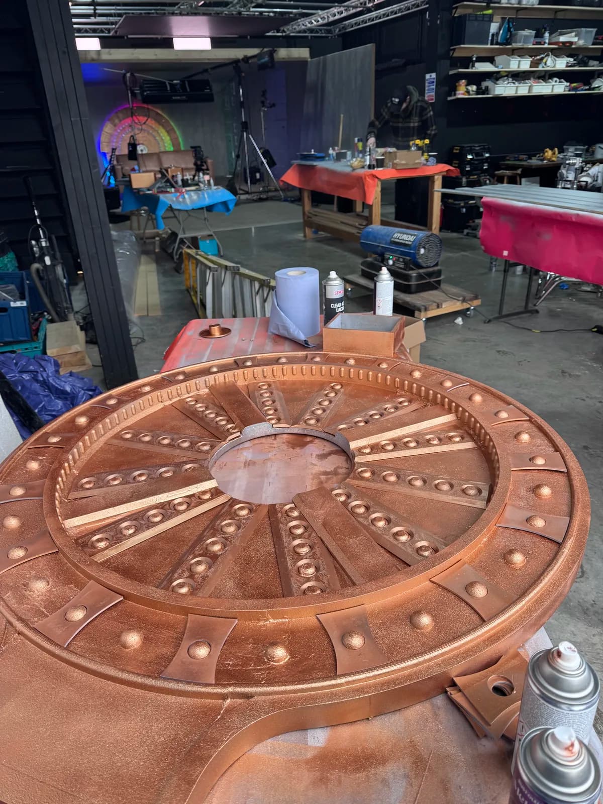 Circular vault-door face lying flat in the workshop before assembly