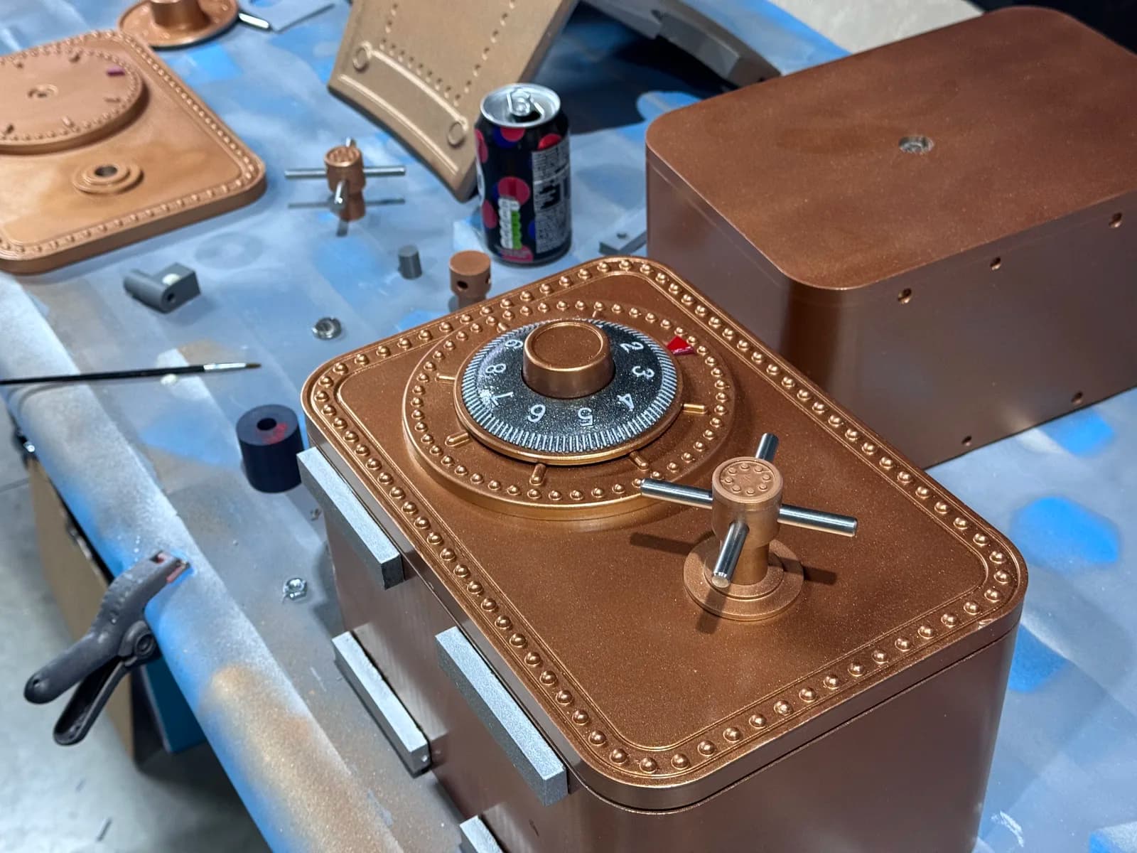Copper safe prop with a numbered dial and handle on a workbench
