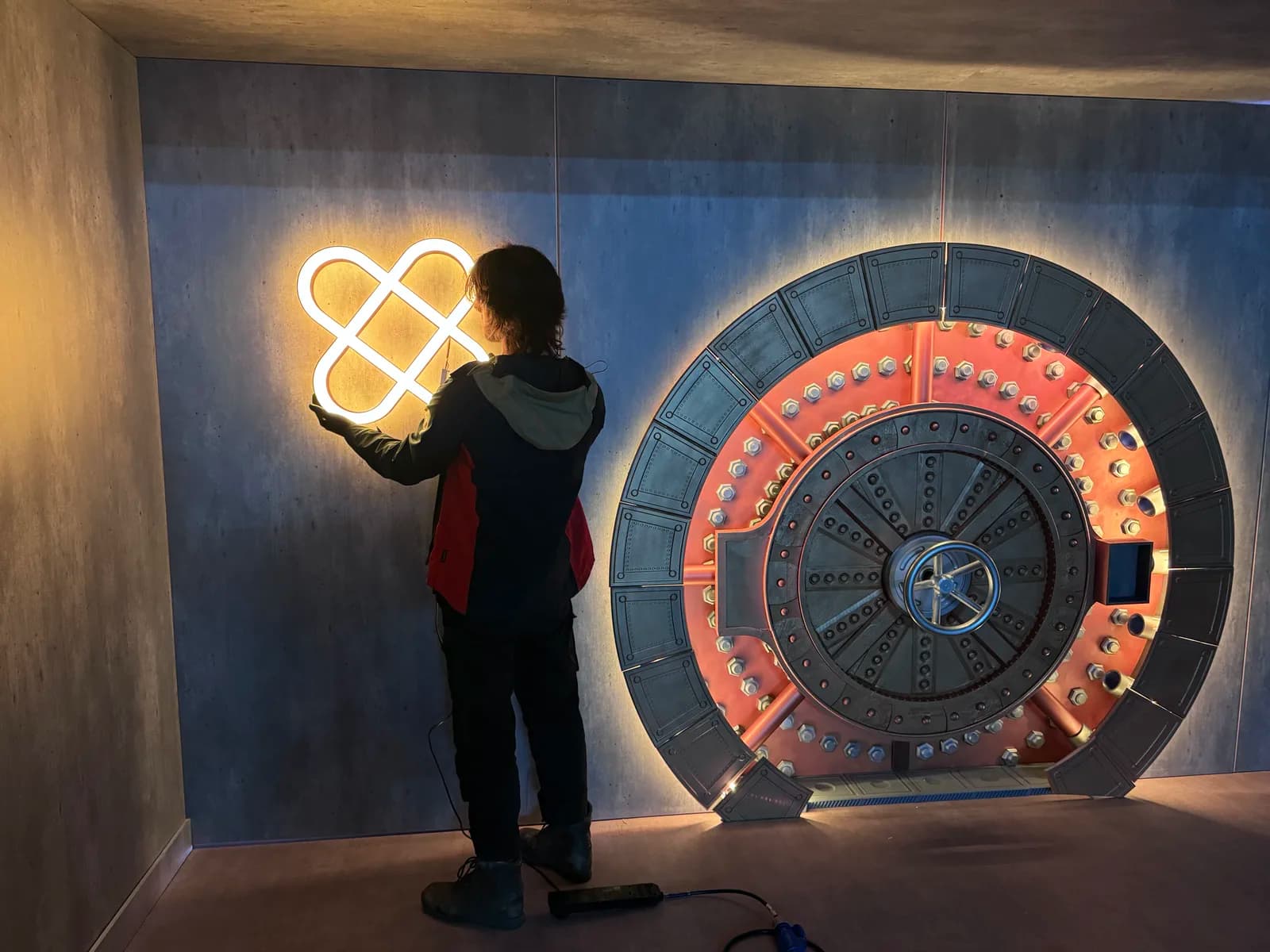 Crew member adjusting the lighting beside the installed vault door