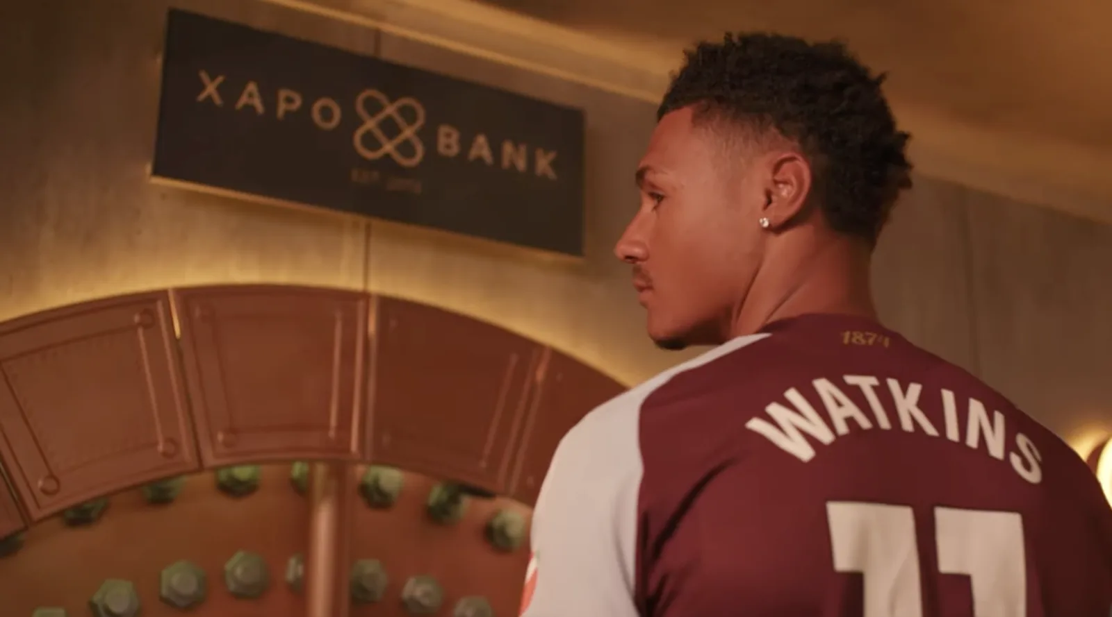 Footballer beside the vault door beneath the Xapo Bank sign